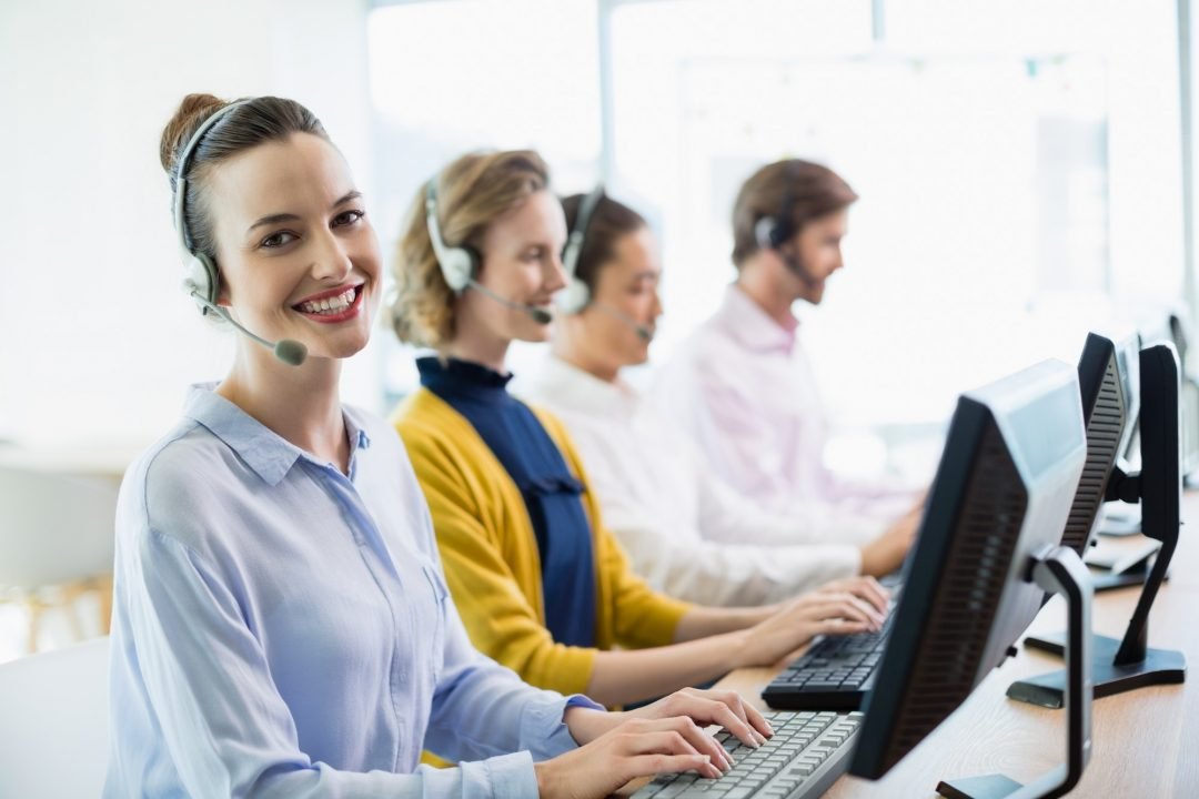 Asesores comerciales sonriendo mientras trabajan